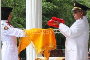 Gubernur Aceh dr Zaini Abdullah menyerahkan bendera merah Putih kepada anggota paskibraka.(LGco-aman.ZaiZa)
