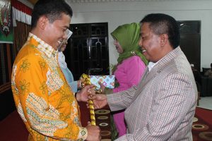 Wakil Bupati Gayo Lues Adam SE memberikan cindera mata kepada Kapolres lama AKBP Achmadi saat lepas sambut di Bale Musara Blangkejeren. (LGco_Anuar Syahadat)