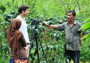 Zaini (kanan) sedang memberi penjelasan tentang kopi Arabika kepada seorang wisawatan mancanegara April 2013 lalu. (Kha A Zaghlul)