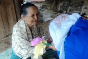 pembagian bunga oleh mahasiswa KPM ke salah satu ibu di desa Teupin Batee. (LGco-Zuhra Ruhmi)