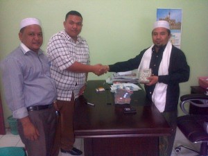Ketua Gepmat Faisal Kadri Ndube S Sos, saat memberikan bantuan uang Rp 63 Juta untuk Paletina kepada Ketua KNURP Ust H. Imran LC. Rabu (6/8).(LGco_Zulfan)