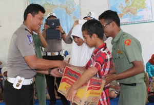 Kasat Lantas Polres Gayo Lues Iptu Dista Nali serahkan paket sumbangan kepada siswa dan siswi SDLB Mutiara Louser.(LGco_Anuar Syahadat)