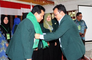 dr Rais sekretaris IDI Aceh memberikan kain kain kepada Ketua IDI Gayo Lues dr.Basumi. (LGco_Anuar Syahardat)