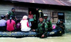 Personel Babinsa Evakuasi Korban Banjir Menggunakan Perahu LCR