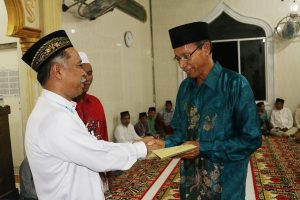Koordinator Safari Ramadhan, Drs. Hasanuddin Darjo, MM, diwakili Kepala UPTD Balai Tekkomdik Dinas Pendidikan Aceh, Drs. Zulkarnaini, saat menyerahkan bantuan Pemerintah Aceh kepada imam masjid di Kabupaten Aceh Barat Daya.