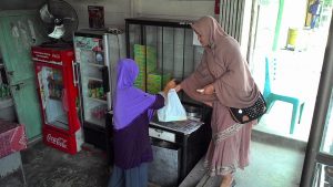 Seorang penjaga outlet Kak Nah melayani pembeli