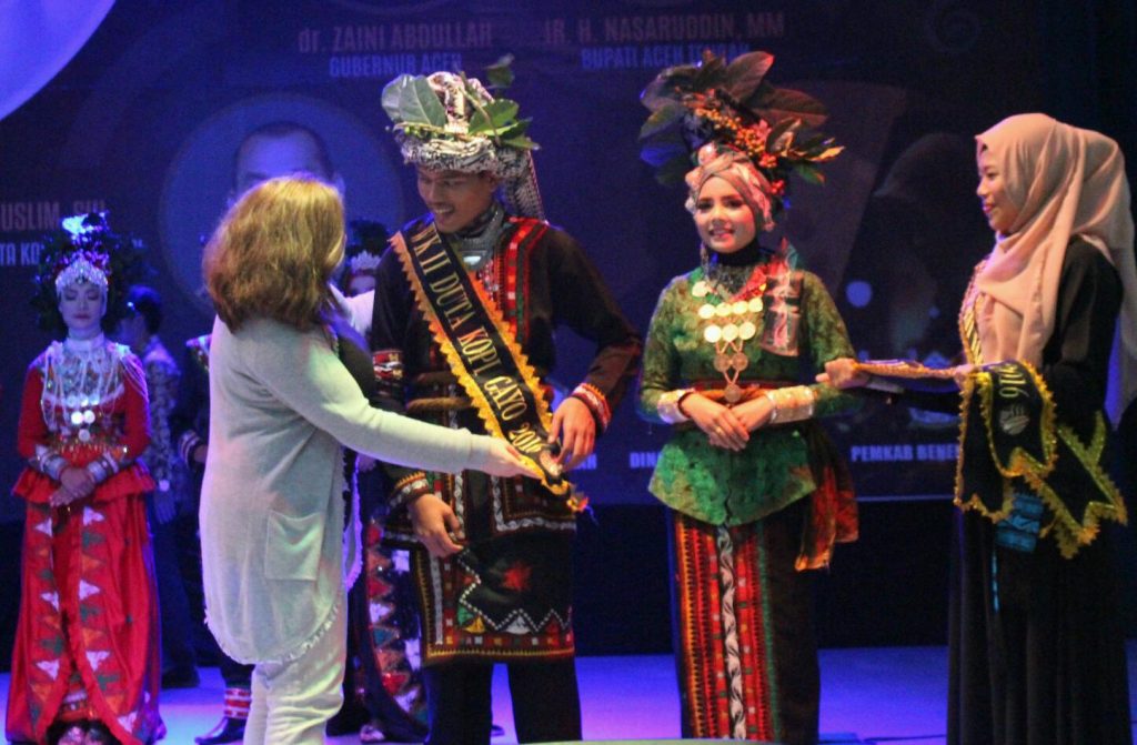 Penyematan selempang untuk satu juara oleh perwakilan juri, Mrs. Judith